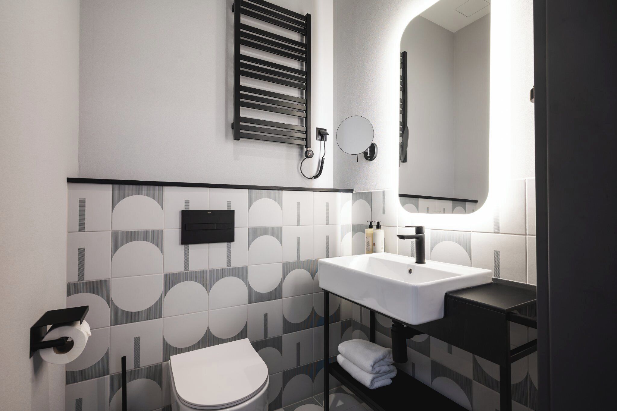 Un baño moderno con inodoro, lavabo y espejo.
