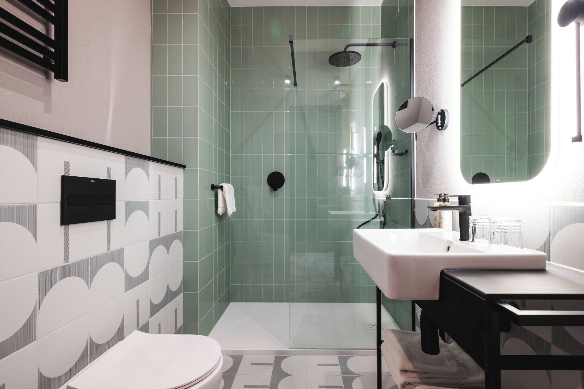 A modern bathroom with a shower, sink, and toilet.