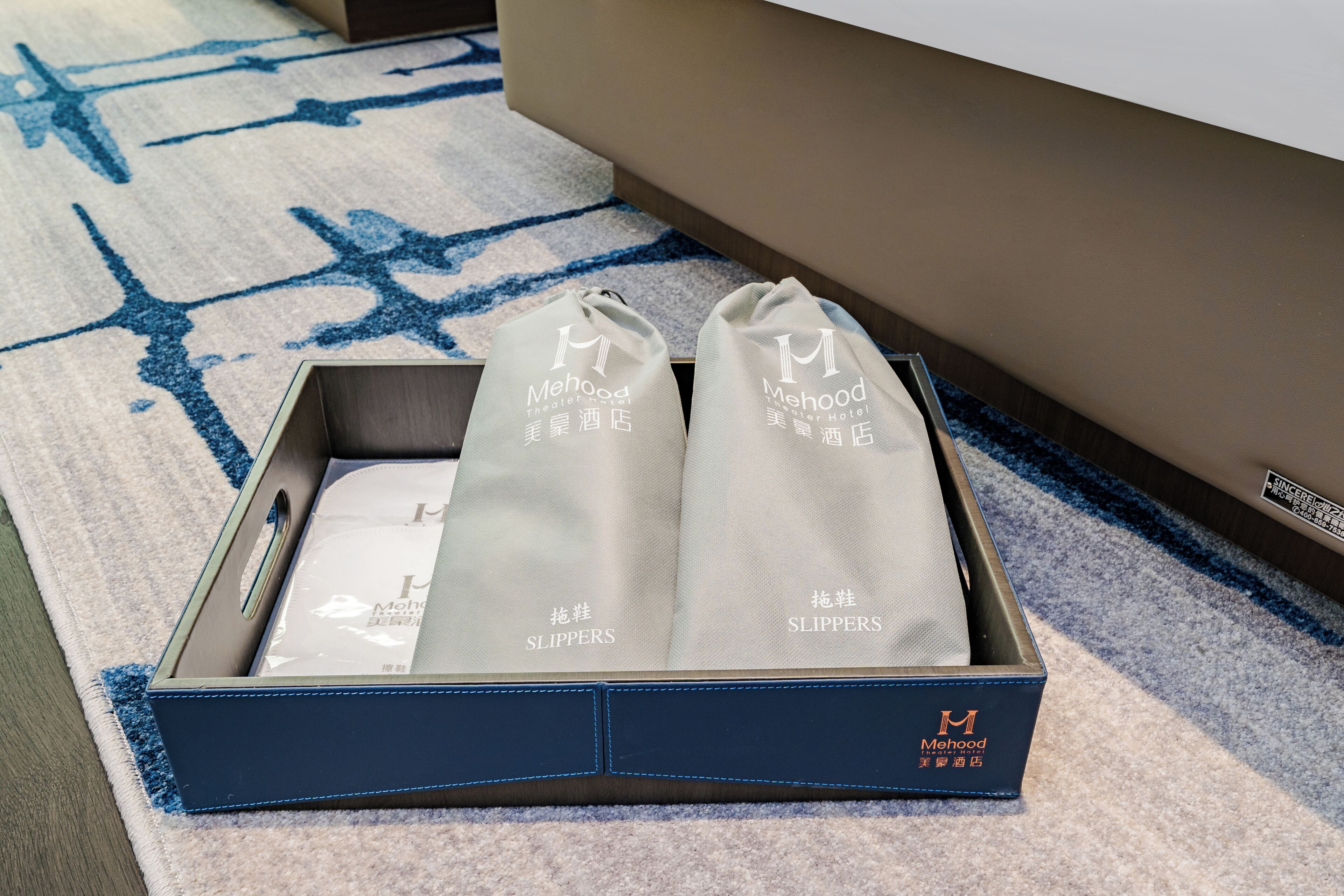 A box containing two pairs of slippers with the brand name 'Mehood' visible.