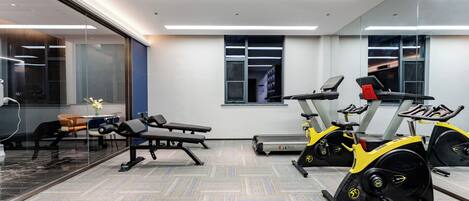 A gym with exercise equipment, a bench, and a treadmill.