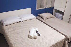 A double bed with two pillows, a blanket, and two rolled towels. - Pousada Porto Maresias (Cabo Frio)