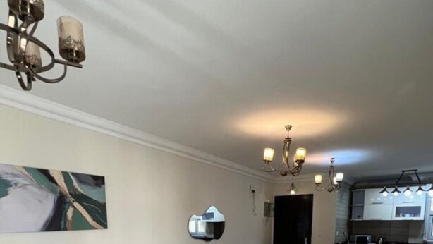 Ein geräumiges Wohnzimmer mit einer Couch, einem Couchtisch, einem Teppich und einem Essbereich.