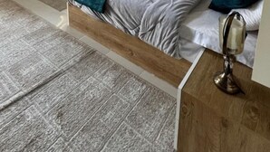 Ein modernes Schlafzimmer mit Bett, Nachttischen, einer besonderen Wandleuchte und einem Deckenventilator.