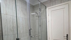 Ein Badezimmer mit Duschkabine, Badewanne, Waschbecken und Waschmaschine.