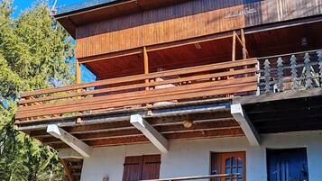 A two-story wooden building with a balcony and a wooden staircase.