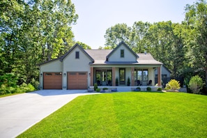 A two-story house with a front porch, a driveway, and a well-maintained lawn.