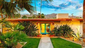 A modern house with a yellow facade, a blue door, and a concrete pathway leading to the entrance. - Amazing Reviews, Perfect 4 Families -Pool, Jacuzzi (Palm Springs)