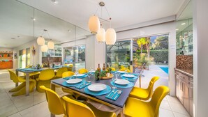 A modern dining area with yellow chairs, a black table, and white plates. - Amazing Reviews, Perfect 4 Families -Pool, Jacuzzi (Palm Springs)