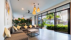 A modern living room with a sofa set, a coffee table, and pendant lighting. - Villa Bae by GORO (Bali)