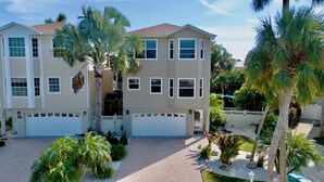 A two-story house with a garage, surrounded by palm trees and a well-maintained garden. - Ilha Bella-Private pool in Holmes Beach (Holmes Beach)