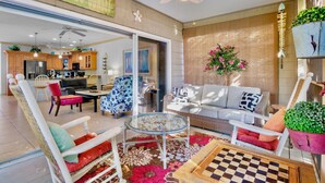 A spacious living area with a sofa, chairs, a coffee table, and a chessboard. - Ilha Bella-Private pool in Holmes Beach (Holmes Beach)