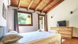 Une chambre à coucher avec un lit, une télévision et une commode en bois.