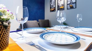 Een eettafel gedekt met borden, glazen en bestek, met een blauw-wit geruit tafelkleed.