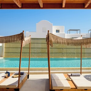A rooftop pool area with lounge chairs and a pool. - Safrani Suites (Santorini)