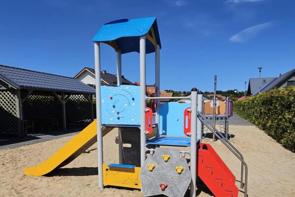 A playground with a slide and climbing structures.