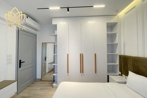 Een moderne slaapkamer met een bed, een inloopkast met schuifdeuren en een nachtkastje.