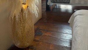 A room with a bed, a wicker basket with pampas grass, and a view of the outside through an open door. - Hotel Colonial Abejorral (Abejorral)