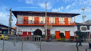 A two-story building with a balcony on the upper floor, a signboard, and a street in front. - Hotel Colonial Abejorral (Abejorral)