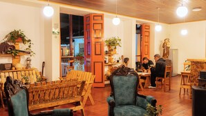 A cozy interior with wooden furniture, a piano, and potted plants. - Hotel Colonial Abejorral (Abejorral)