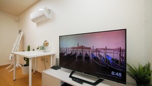 Un téléviseur à écran plat, fixé sur un support blanc, affiche un paysage pittoresque de Venise.