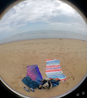A beach scene with two beach towels and a backpack on the sand. - Gîte 'lavande' with Heated Pool, Countryside, Near Ocean and Forest, Marais Poitevin (Nalliers)