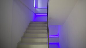 A staircase with white steps and blue lighting. - Sea Apartment (Nocera Terinese)