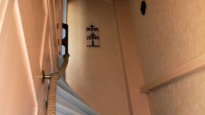 A corridor with a beige wall, a door with a beige handle, and a white door with a beige doorknob. - Holiday Home “Les Flots Bleus Cancale” with Private Terrace, Garden & Wi-Fi (Cancale)