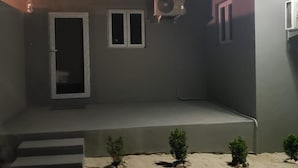 Un edificio con techo plano, un pequeño porche y una sola puerta.