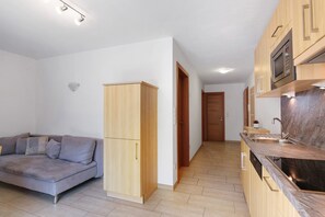 Eine moderne Küche mit Holzausstattung, einer eingebauten Mikrowelle und einem Edelstahl-Spülbecken.