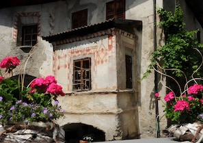 Un bâtiment doté d’une petite fenêtre, d’une porte et d’un mur orné d’un motif géométrique.