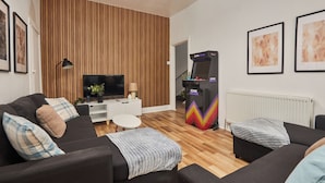 A modern living room with a flat-screen TV, a gaming console, and a white round coffee table. - Ladykirk Road (Newcastle-upon-Tyne)