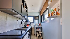 A compact kitchen with a black countertop, a built-in oven, and a window above the sink. - Apartment Anglet Chiberta, beaches, surf, golf, parking, air conditioning (Anglet)