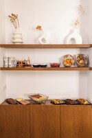 Una mesa buffet de madera con diversos alimentos y jarrones decorativos.