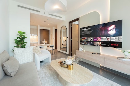 Apartamento luxo, sacada, vista para a piscina | Área de estar | Smart TV 65 polegadas com canais digitais, Netflix. Chic 1BR Apartment - The Crest Dubai