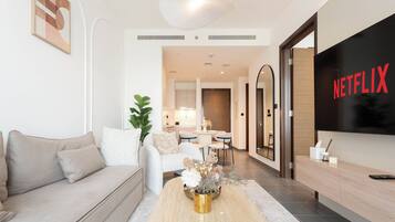 Apartamento luxo, sacada, vista para a piscina | Área de estar | Smart TV 65 polegadas com canais digitais, Netflix