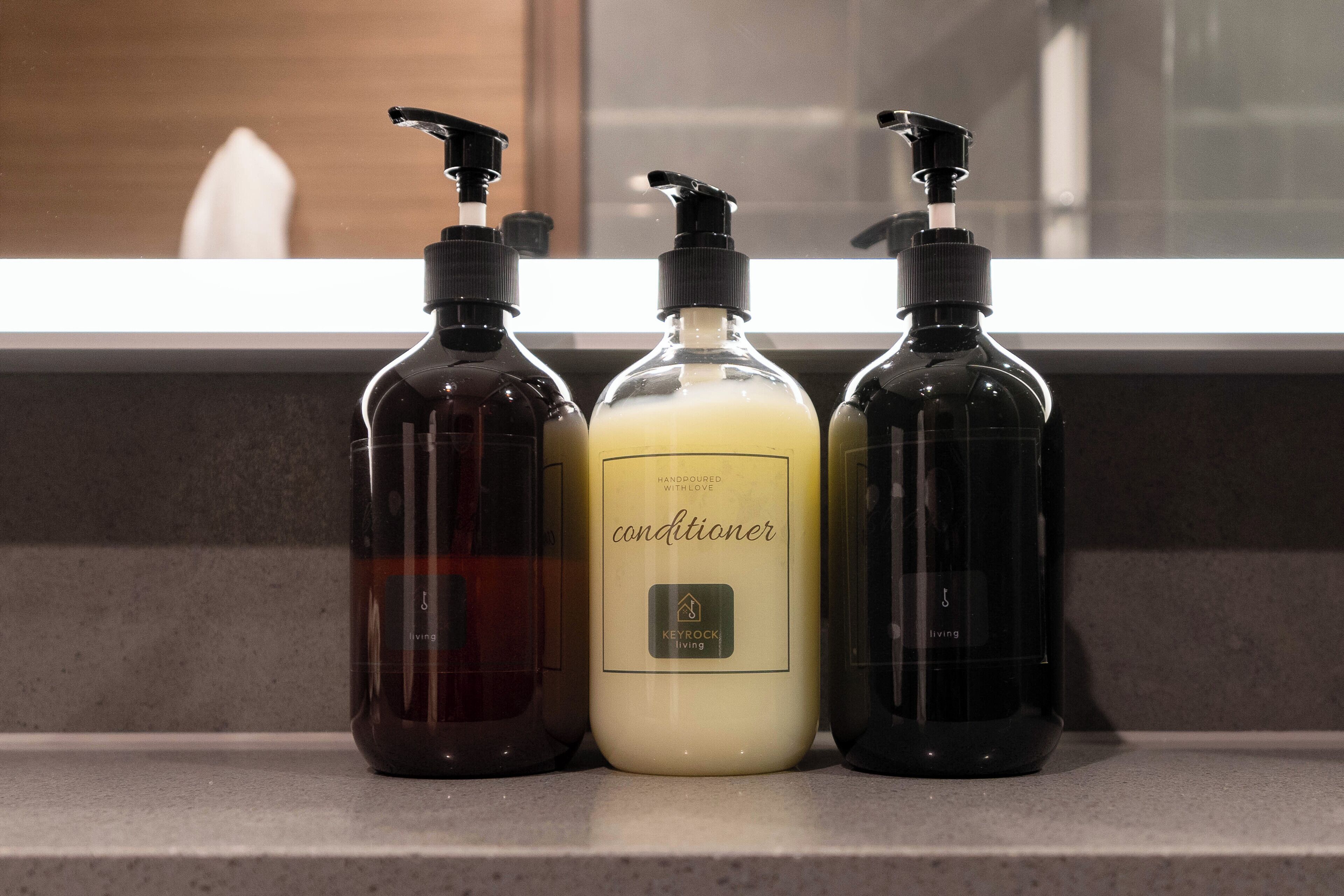 Three bottles of conditioner on a countertop.