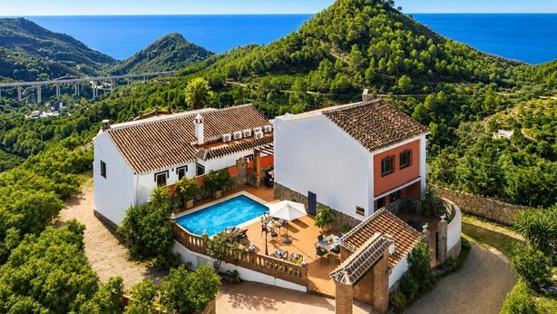 A two-story house with a swimming pool, surrounded by lush greenery and a view of the sea. - Villa Alvarez - Three Bedroom Villa, Sleeps 6 (Almuñécar)