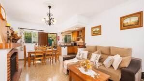 A living room with a sofa, coffee table, and dining area with chairs and a table. - Villa Alvarez - Three Bedroom Villa, Sleeps 6 (Almuñécar)
