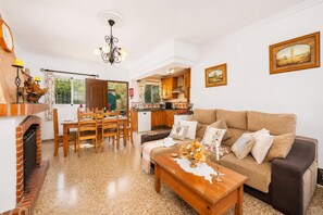 A living room with a sofa, coffee table, and dining area with chairs and a table. - Villa Alvarez - Three Bedroom Villa, Sleeps 6 (Almuñécar)