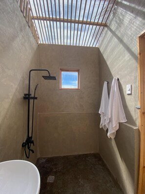 A small, enclosed shower area with a window, a towel rack, and a bathtub. - Glamping at Kalumo Lodge - Tent 2 (Oslob)