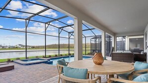 Eine überdachte Terrasse im Freien mit Pool, Sitzgelegenheit und Seeblick.