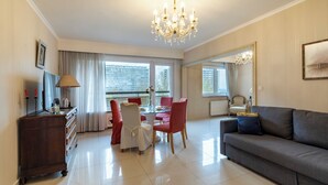 A living room with a sofa, dining table, chairs, and a chandelier. - Brussels Expo Elegant residence (Brussels)