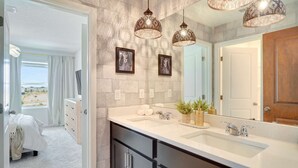 A bathroom with a large mirror, two pendant lights, a sink, and a vanity with cabinets. - 7‑BR w/ Private Pool & Game Room (Kissimmee)