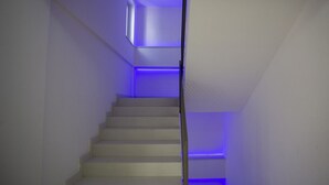 A narrow staircase with white walls and blue lighting. - Sea Apartment - with shared Pool (Villaggio del Golfo)