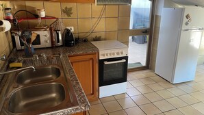 Eine Küche mit doppelter Spüle, Herd, Backofen und Kühlschrank.