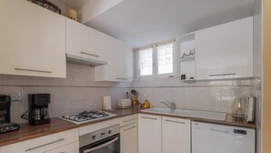 A kitchen with white cabinets, a gas stove, a coffee maker, and a dishwasher. - Apartment 'À Ria-sirach' with Mountain View, Shared Terrace and Wi-Fi (Ria-Sirach)