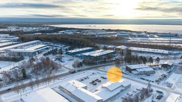 Vista aérea de una zona industrial cubierta de nieve, con varios edificios y estacionamientos.