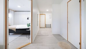 Un dormitorio moderno con cama, mesita de noche y una planta en maceta.