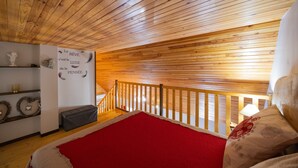 A wooden ceiling, a red carpet, a white wall with text, and a wooden railing.