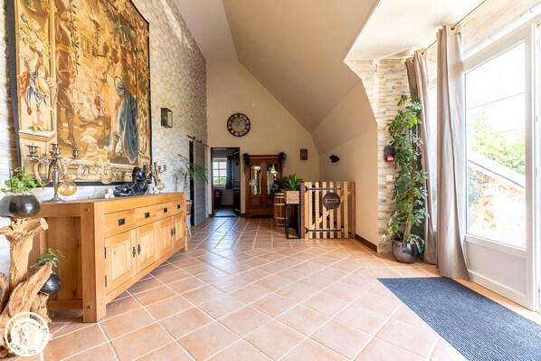 A spacious hallway with a wooden cabinet, a large mural, and a clock on the wall. - Cupidon Guest Room with Mountain View, Wi-Fi, and Air Conditioning (Singles)